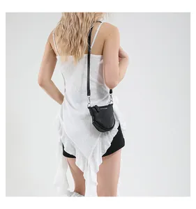 Détail du mini sac bandoulière noir en cuir grainé avec boucles métalliques argentées