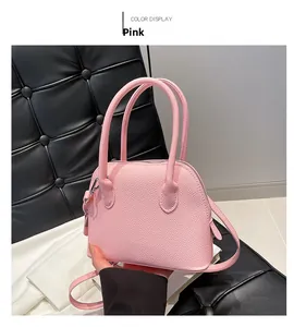 Sac coquille rose avec texture grainée et double poignée en gros plan détaillé