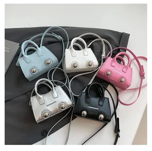Five minimalist trapezoid handbags in various colors arranged on a grey blazer background