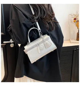 Detail der silbernen Metallic-Box-Handtasche mit Tragegriff und verstellbarem Schultergurt