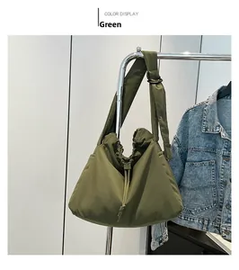 Detail of green drawstring nylon tote bag showing wide shoulder strap and black adjustment ring