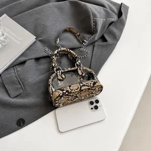 Détail d'un mini sac en PVC zébré avec chaîne argentée et smartphone pour comparer la taille