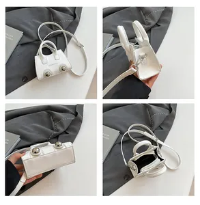 Detail view of white PU leather mini bag featuring silver studs and fashion typography