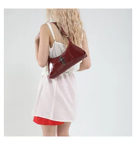 Model view of burgundy glossy patent leather shoulder bag with cross chain detail