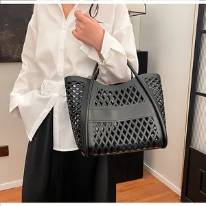 Detail view of a black hollowed-out tote bag featuring a diamond-cut geometric pattern
