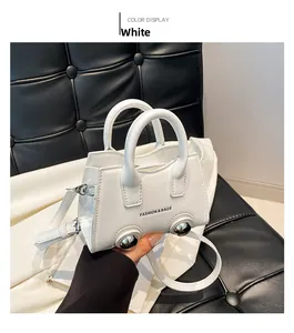 White mini handbag with rigid handles and removable strap on black quilted seat
