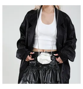 Nahaufnahme einer weißen Mini-Schleifentasche mit langer Perlenkette an einem Model
