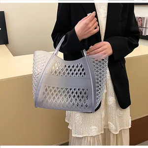 Detail of translucent gray hollow-out tote bag with geometric diamond patterns