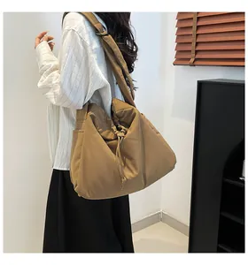 Detailed side view of khaki nylon tote bag featuring drawstring pleats and wide strap
