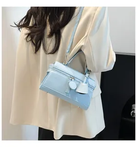 Detailansicht der hellblauen Ledertasche mit Metallfüßen und abnehmbarem Schultergurt