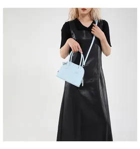 Détail du sac à main bleu clair en cuir grainé avec fermeture éclair argentée et poignées