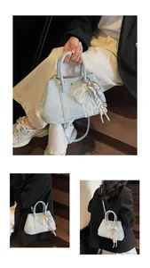Detail of light blue handbag with white lace trim and silver silk bow accessory