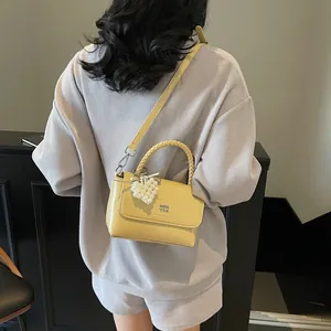 Chic yellow crossbody handbag with pearl heart charm and woven handle for women