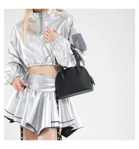 Vue détaillée du sac à main noir texturé associé à une tenue argentée tendance