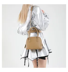 Modèle avec sac bandoulière kaki en forme de coquille à texture grainée et poignées