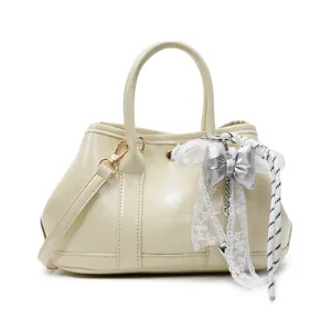 Chic cream white PU leather tote with lace bow charm and crossbody strap on white background
