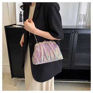 Close-up of holographic sequin shell bag with pearl and diamond accents on gold metal frame