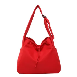 Bright red nylon drawstring tote bag with adjustable shoulder strap and side pockets