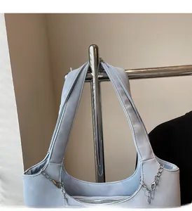 Detail of light blue shoulder bag showing soft leather texture and metallic chain decoration