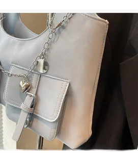 Detail of light blue faux leather bag with silver heart charm and metal chain