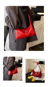 Three-way view of shiny red patent leather crescent shoulder bag with silver buckle