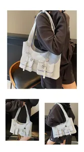 Detail of gray leather shoulder bag with twin flap pockets, silver chains and heart charms