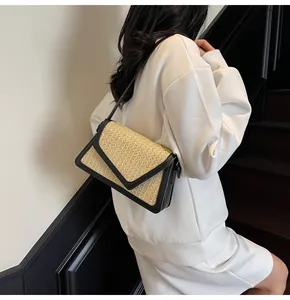 Gros plan d'un sac bandoulière en paille tressée avec bordure en cuir noir et rabat en V