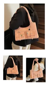 Pink suede tote bag with chain pendants shown in a lifestyle urban setting on stairs