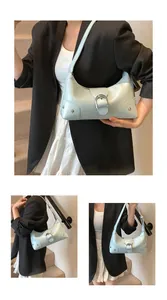 Close-up of light blue patent leather crescent bag with a large silver metal buckle