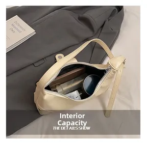 Internal capacity of the cream leather shoulder bag showing storage for daily essentials