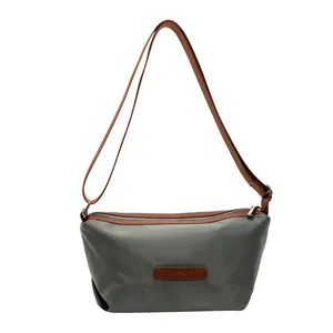 Grey oxford cloth shoulder bag with brown leather accents and adjustable strap for women