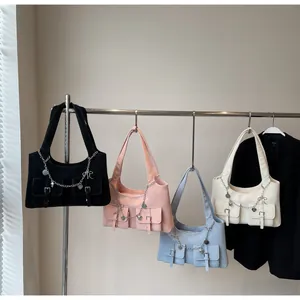 Detail of four colorful shoulder bags with heart chains and pockets on a rack