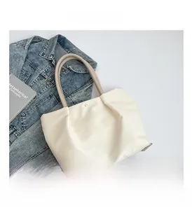 Close-up of waterproof nylon tote bag with golden magnetic clasp and khaki handles