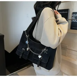 Detail of black large capacity shoulder bag with silver chains and heart charms