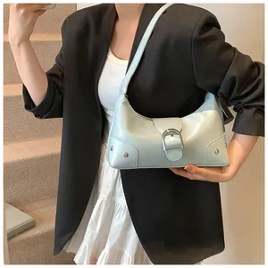 Detail of light blue hobo bag with glossy finish and large silver buckle hardware