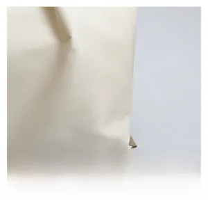 Close-up detail of premium waterproof beige nylon fabric showing soft texture and fine grain