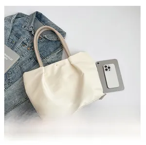 Top view of cream white PU leather tote bag showing magnetic buckle and spacious interior