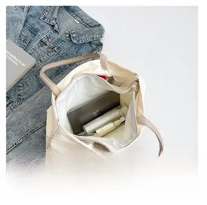 Spacious interior of a waterproof nylon tote bag holding a laptop and cosmetics