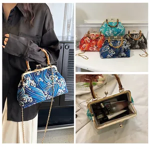 Détail du sac vintage avec poignée en bambou, motif vague, fermoir métal et chaîne dorée