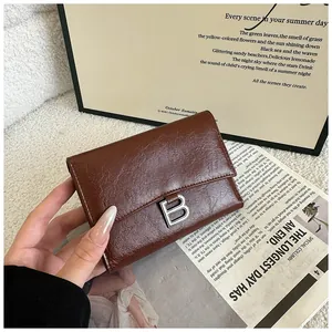 Detailed view of brown oil-wax leather wallet with vintage texture and silver B-buckle