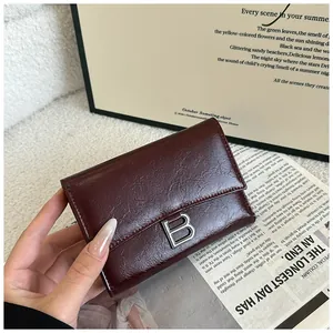 Macro detail of wine red leather wallet with vintage texture and silver metal B buckle