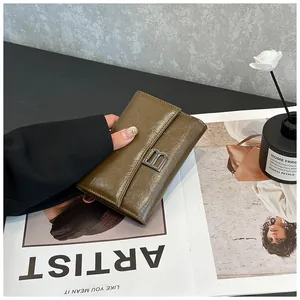Detail of vintage brown leather wallet featuring a stylish metal B buckle on a magazine