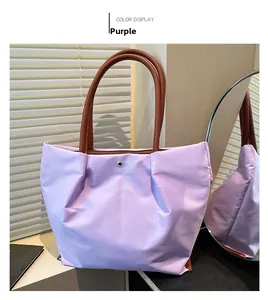 Close-up of waterproof nylon tote in purple with brown straps and silver snap button