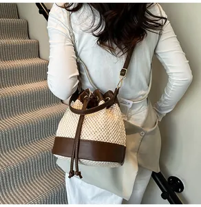 Close-up of woven bucket bag with leather trim on model for summer styling