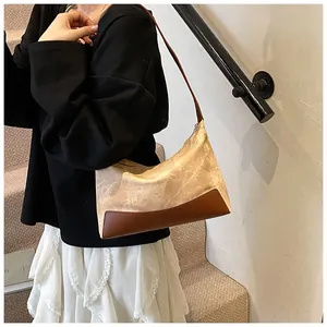 Detailed view of a retro color-block underarm bag worn by a model in a minimal setting