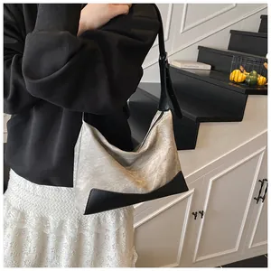 Lifestyle shot of grey textured and black leather contrast crossbody shoulder bag