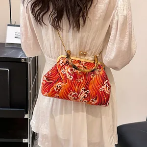 Sac à main avec poignée en bambou et motif de vagues porté à l'épaule par un mannequin
