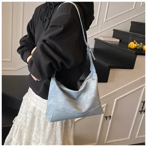 Detail of light blue crossbody bag with vintage matte texture and smooth leather base
