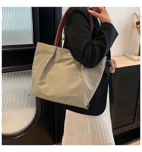 Detailed view of large capacity waterproof nylon tote bag showing texture and leather handles