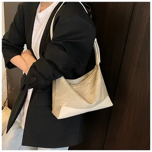 Detail of canvas and leather patchwork tote bag featuring metal zipper and shoulder strap